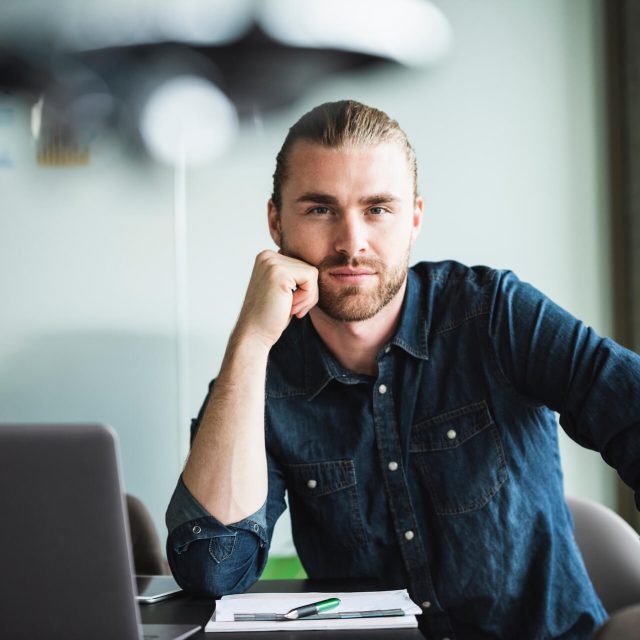 portrait-of-confident-casual-businessman-at-desk-i-2022-03-08-01-31-22-utc.jpg